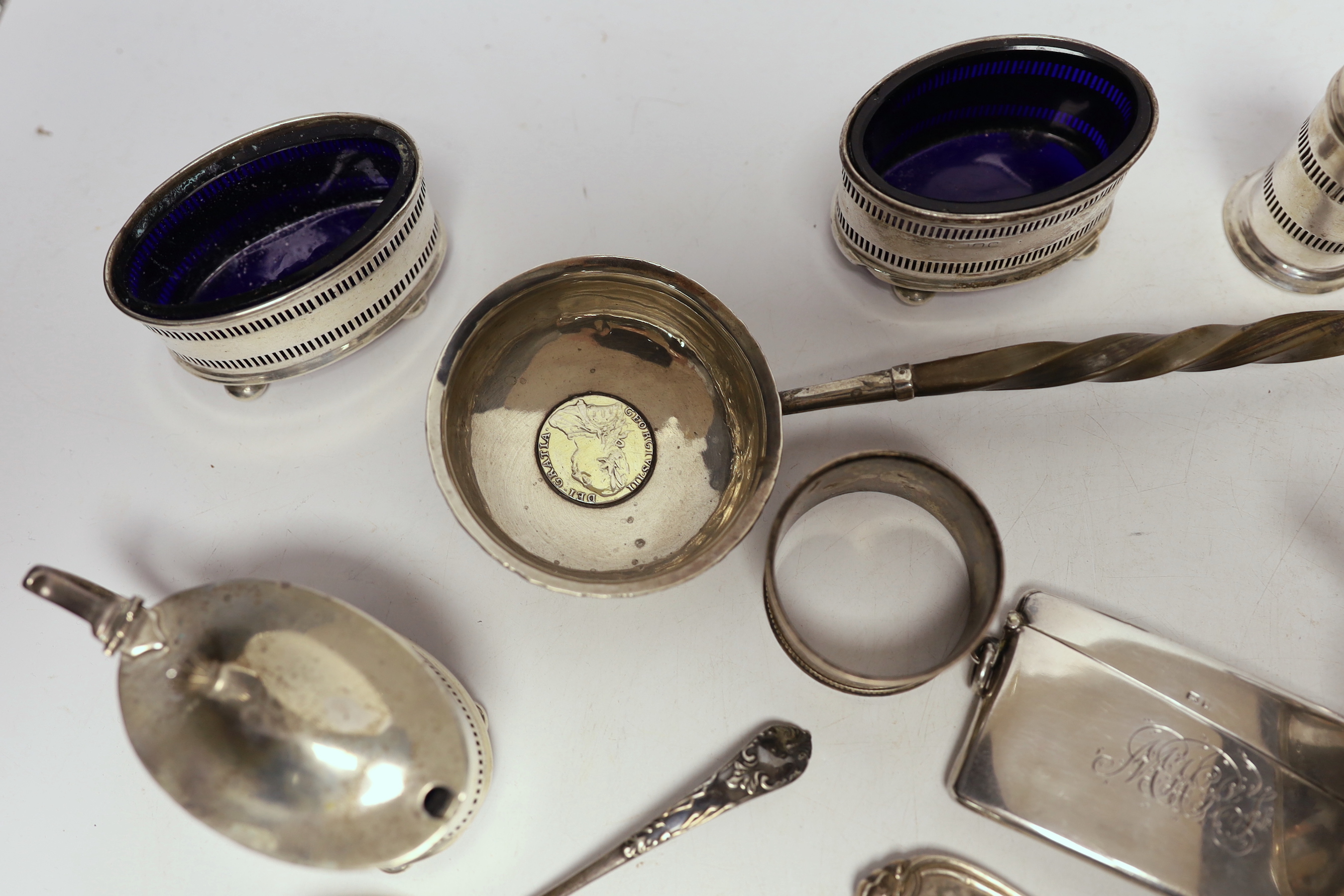 A 1930's silver single handled cup, a four piece silver condiment set, Edwardian silver card case, pair of silver pepperettes, napkin rings, sundry small flatware including sterling etc.